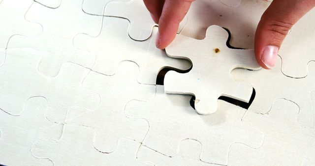 Hands are placing a puzzle piece into its correct position, with copy space. Puzzle-solving symbolizes problem-solving skills and the concept of finding solutions.