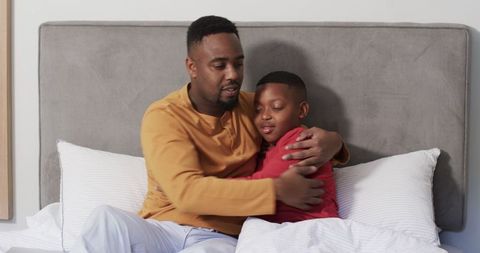 Father and Son Embracing on Bed with Heartfelt Connection