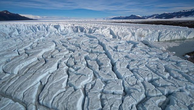 Fractured glacier tongue revealing deep crevasses and seracs on arctic icefield