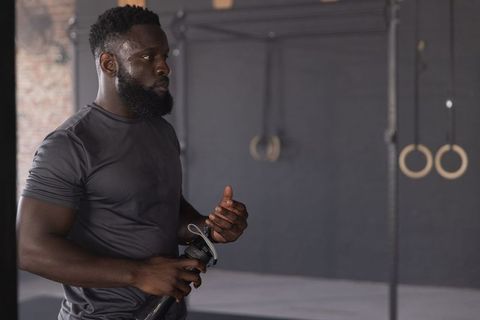 African american athlete holding shaker preparing for intense workout in industrial gym