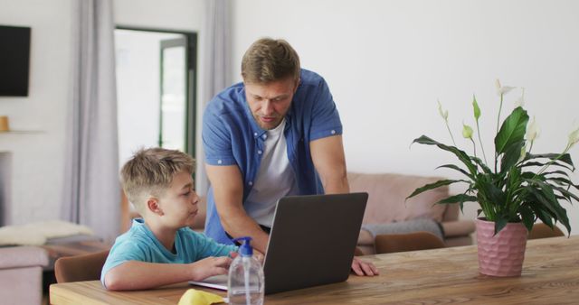 Caucasian father and son using laptop in dinning room - Download Free Stock Photos Pikwizard.com