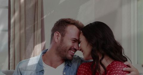 Happy Couple Embracing Affectionately on Cozy Sofa at Home