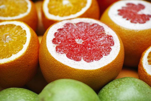 Closeup of freshly sliced citrus fruits including grapefruits and oranges. Perfect for promoting healthy eating, showcasing fresh produce or as colorful decorations in kitchen-related themes.