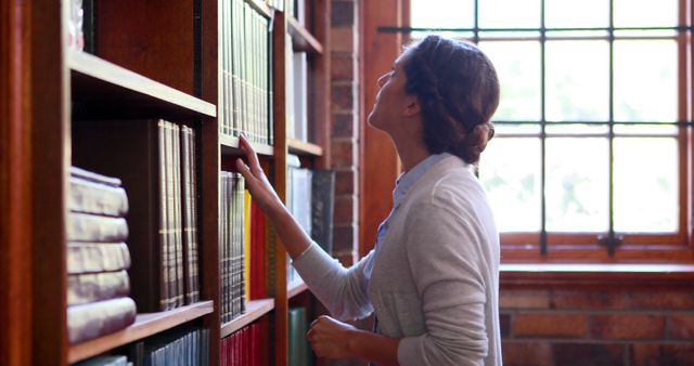 Young Woman Searching for Book in Library - Download Free Stock Images Pikwizard.com