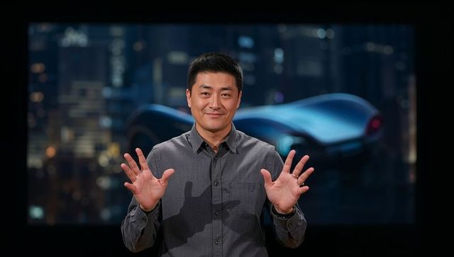 Standing Asian presenter raising hands on studio stage with futuristic cityscape backdrop