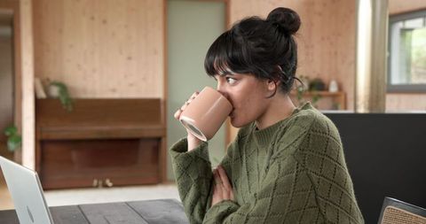 Woman Enjoying Coffee While Working at Cozy Home Office