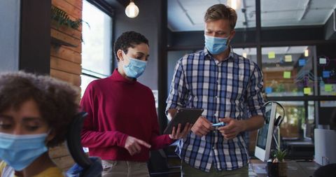 Masked Colleagues Collaborating in Modern Office
