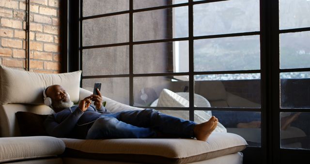 Relaxed Man Listening to Music While Using Smartphone at Home - Download Free Stock Images Pikwizard.com