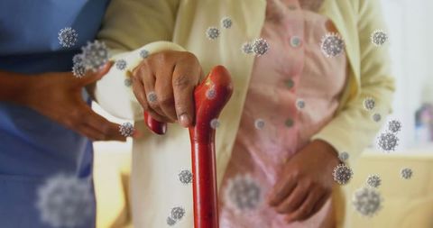 Healthcare worker assisting elderly woman with virus particles