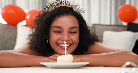 Cheerful Woman Celebrating Birthday with Cupcake and Candle