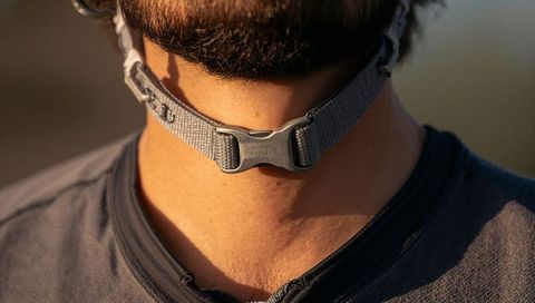 Bearded man wearing gray chin strap buckle at golden hour closeup