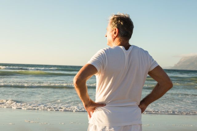 Senior Man Standing on Beach Looking at Ocean - Download Free Stock Photos Pikwizard.com