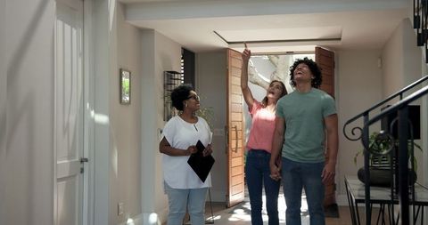 Diverse Real Estate Agent Showing Young Couple Modern Home Interior