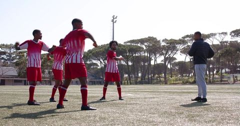 Soccer team in red uniforms warming up for match