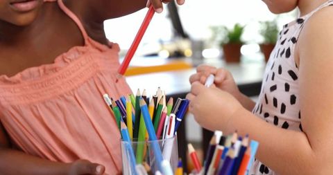 Children Sharing Colored Pencils for Creative Art Activity