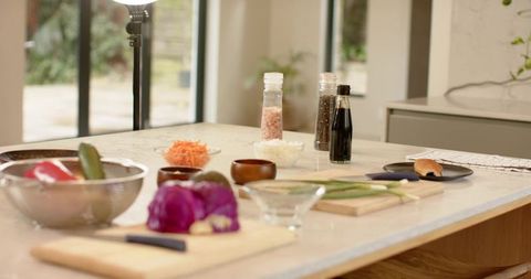 Preparing fresh vegetables on modern kitchen island with halved purple cabbage and knives