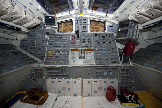 Cockpit of Space Shuttle Endeavour undergoing dismantling at NASA's Kennedy Space Center. Control panels and buttons fill the cockpit as part of Endeavour's transition and retirement processing. Utilized for educational materials on space missions, detailed look at spacecraft controls, historical displays of space shuttles.