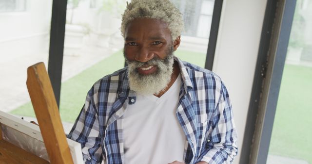 Image of african american senior man painting picture. retirement lifestyle, spending time alone at home concept digitally generated image.