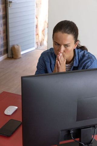 Woman Focused on Computer Monitor in Home Office Setting