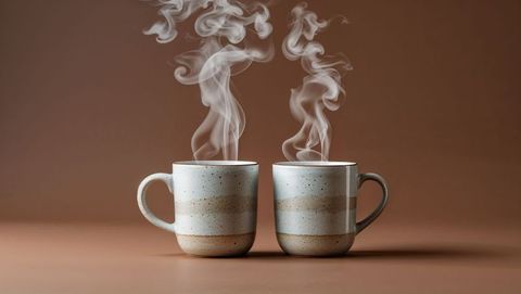 Two steaming ceramic mugs on brown table for cozy minimalistic design