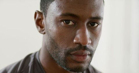 Contemplative african american man closeup portrait showing natural skin texture, stubble