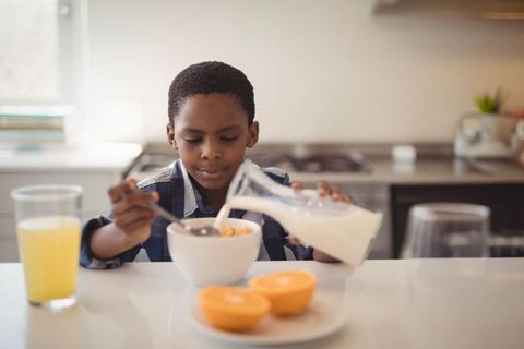 Young Boy Enjoying Healthy Breakfast with Cereal and Milk