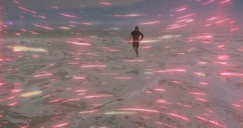 Running hooded athlete on stormy beach with magenta light streaks and foam trails