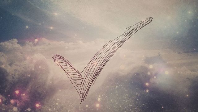 Abstract hand-drawn check mark in serene cloudscape