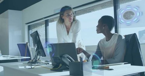 Businesswomen engaged over data analysis in modern office