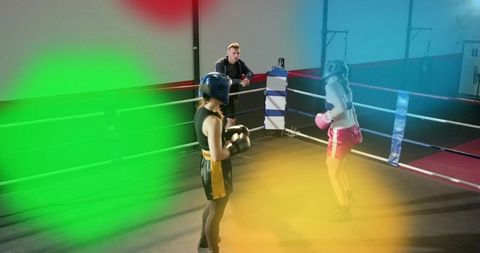 Female Boxers Sparring in Gym Ring with Coach Observing Intense Training Session