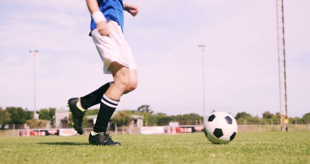 A young Caucasian athlete is in motion, playing soccer on a sunny field, with copy space - Download Free Stock Photos Pikwizard.com