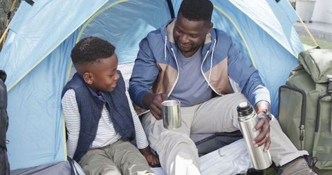 Father and Son Bonding While Camping in Cozy Tent Environment