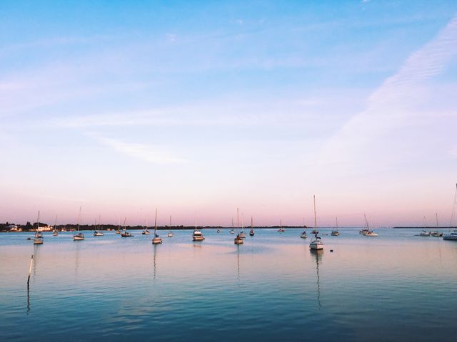 Serene Seascape at Dawn with Boats Anchored in Calm Water - Download Free Stock Photos Pikwizard.com