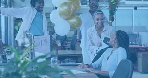 Team Celebrating Coworker Promotion in Open-Plan Office with Balloons and Flowers