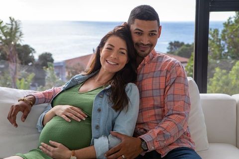 Diverse couple enjoying ocean view in modern living room