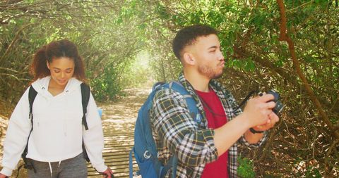 Happy Couple Exploring Sunlit Forest Trail