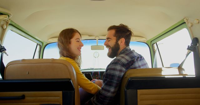 Happy young couple interacting with each other in van. Having fun on roadtrip 4k