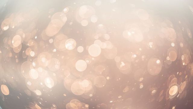 Ethereal glowing peach bokeh field spilling warm light across neutral gradient backdrop