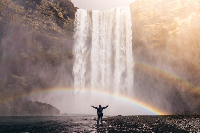 Traveler Enjoying Majestic Waterfall with Rainbow - Download Free Stock Photos Pikwizard.com