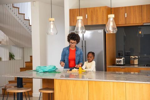 Mother and daughter bonding in modern kitchen preparing lunch