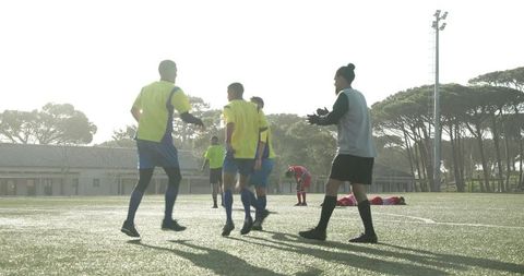 Soccer team celebrates victory goal in evening sunlight