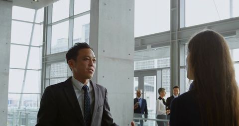 Business Professionals Engaged in Discussion in Modern Office Lobby