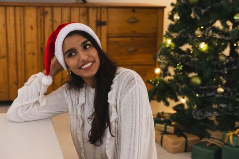 Smiling Woman with Santa Hat Enjoying Christmas Moments Indoors