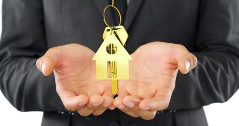 Businessman Holding Golden House Key Symbolizing Real Estate Investment - Download Free Stock Images Pikwizard.com