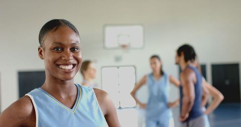 Confident Female Athlete Smiling on Indoor Basketball Court