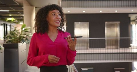 Professional Woman Recording Message on Smartphone in Modern Office