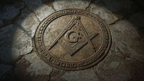 Masonic bronze freemasonry emblem on ancient stone floor
