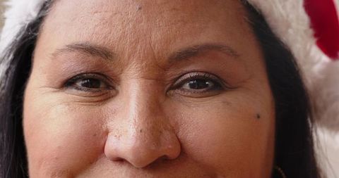 Close-Up Portrait of Woman in Santa Hat Embracing Holiday Cheer