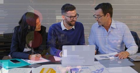Business team reviewing data analytics and charts around laptop with documents and folder
