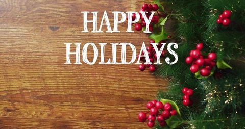Rustic happy holidays greeting on wooden plank with pine sprigs and red berries